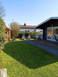 a backyard with a lawn and a house at Ferienhaus kleines Ostseeglück in Brodersby