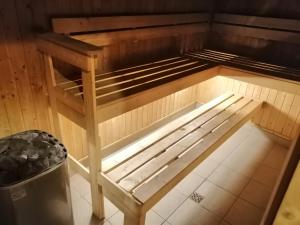 a wooden bed in a room with a trash can at Marsden Suites Nautilus Orewa in Orewa