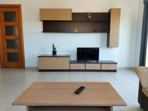 sala de estar con TV y mesa de centro en Ático Aire del Andarax con terraza y aparcamiento entre el mar y desierto - Alborania, en Viator