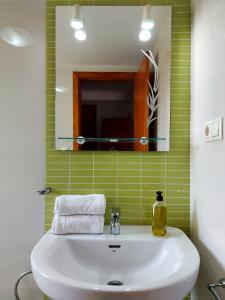 bagno con lavandino bianco e specchio di Ático Aire del Andarax con terraza y aparcamiento entre el mar y desierto - Alborania a Viator
