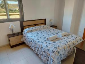 1 dormitorio con 1 cama, 2 mesas y una ventana en Amplio ático con terraza y aparcamiento entre el mar y desierto - Alborania, en Viator