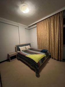 - une chambre avec un lit doté d'une couverture jaune et d'une fenêtre dans l'établissement Dawa guest house, à Addis-Abeba