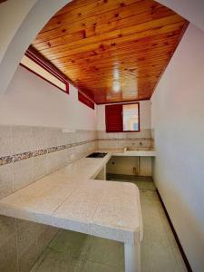 a kitchen with a bench in the middle of a room at Hospedaje Finca Bella Vista in Santa Rosa de Cabal