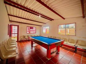 a pool table in a room with chairs at Hospedaje Finca Bella Vista in Santa Rosa de Cabal