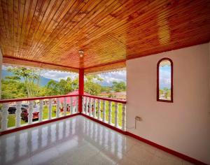 a large room with a balcony with a large window at Hospedaje Finca Bella Vista in Santa Rosa de Cabal