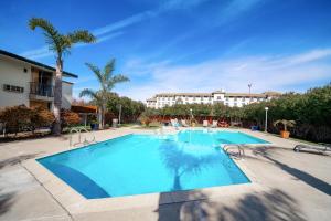 ein großer Pool mit einem Hotel im Hintergrund in der Unterkunft Hotel Calle Joaquin - San Luis Obispo in San Luis Obispo