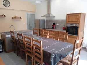 kuchnia ze stołem i krzesłami oraz kuchnia z kuchenką w obiekcie Gite A la bonne fermière w mieście Nevy-sur-Seille