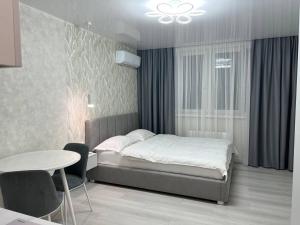 a bedroom with a bed and a table and chairs at Deluxe apartments - Viva Ukraine in Kyiv