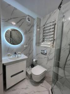 a bathroom with a sink and a toilet and a mirror at Deluxe apartments - Viva Ukraine in Kyiv