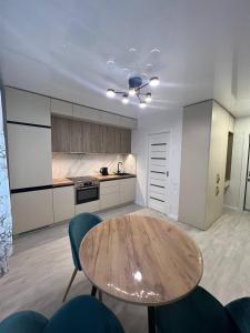 cocina con mesa de madera y sillas en una habitación en Deluxe apartments - Viva Ukraine en Kiev