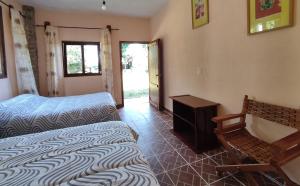 a bedroom with two beds and a table and a window at Aventurec in Piedra Pinta