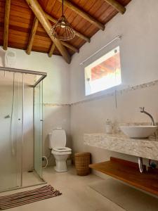 łazienka z umywalką, toaletą i oknem w obiekcie Hashigute Spa e Hostel w mieście Arraial d'Ajuda