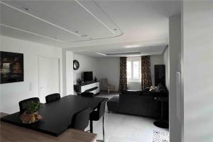 Appartement brest st-marc 6-8personne 2min centre في بريست: غرفة معيشة مع طاولة سوداء وأريكة