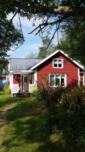 una casa roja y blanca con una puerta blanca en Ferienhaus in Karlsborg mit Offenem Kamin en Mölltorp