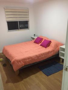 ein Schlafzimmer mit einem großen orangenen Bett mit lila Kissen in der Unterkunft Casona Litril in Dichato