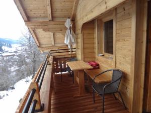 einen Balkon einer Blockhütte mit einem Tisch und Stühlen in der Unterkunft Haus Sonnegg in Fieberbrunn