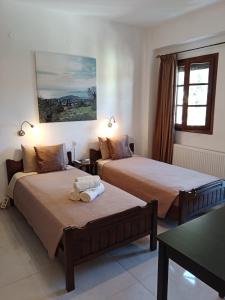 a hotel room with two beds and a table at Karidia Apartments in Kissós
