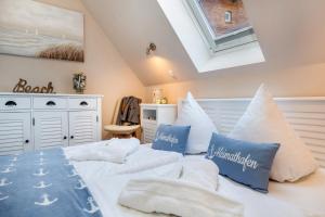 sypialnia z 2 łóżkami i białymi i niebieskimi poduszkami w obiekcie Seebrise Zingst w Zingst
