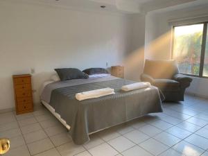 1 dormitorio con 1 cama con silla y ventana en Limpio y confortable depto - Buganvillas 275, en Santa Cruz de la Sierra