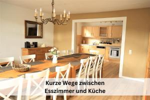 a kitchen and dining room with a table and chairs at Komplettes Ferienhaus für bis zu 15 Personen mit großem Garten, Pool, Dart, Sauna-, Grill- und Fitnessbereich - Ideal für Familien in Eslohe