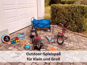 a childs stroller and a bike next to a garage at Komplettes Ferienhaus für bis zu 15 Personen mit großem Garten, Pool, Dart, Sauna-, Grill- und Fitnessbereich - Ideal für Familien in Eslohe