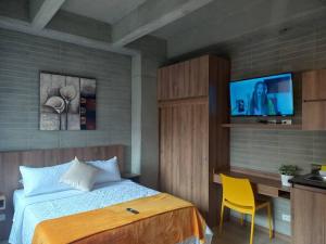 um quarto com uma cama e uma televisão de ecrã plano em 304 Amazing Loft em Medellín