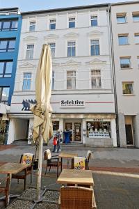 a umbrella and tables and chairs in front of a building at *City, Nähe Hbf, Kingsizebetten, Fitnessecke* in Duisburg
