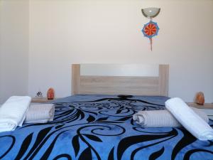 ein Schlafzimmer mit einem Bett mit einer blauen und schwarzen Decke in der Unterkunft Lar Dos Guerreiros in Vila Nova de Milfontes