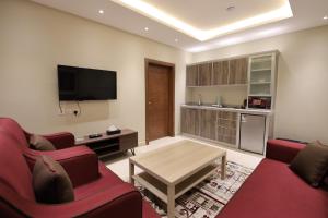 sala de estar con sofá rojo y mesa en قصر السفير شقق فندقية en Riad