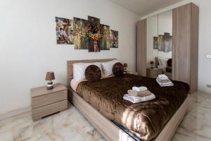 una camera da letto con un grande letto con asciugamani di MADRIGIO... a casa propria a Casamassima