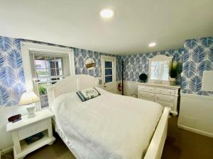 a bedroom with a white bed and blue and white wallpaper at Atlantic House Bed & Breakfast in Ocean City