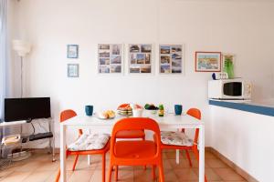 - une cuisine avec une table blanche et des chaises orange dans l'établissement Studio Spoerry YourHostHelper, à Grimaud