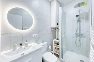 a white bathroom with a sink and a shower at En route la Famille, 8 personnes - Métro 7 in La Courneuve