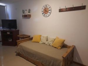 1 dormitorio con 1 cama y reloj en la pared en Alvarado Apart en Bahía Blanca
