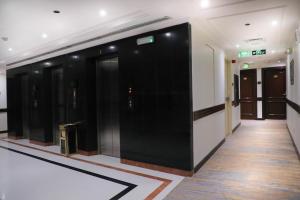 a hallway with black doors in a building at Deyar Al Eiman Hotel in Al Madinah