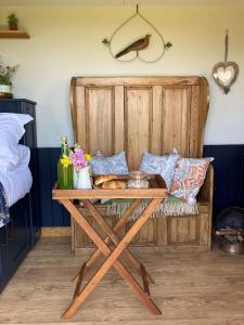 una mesa de madera en una habitación con cama en Marsh Farm Glamping Shepherd Hut en Langport