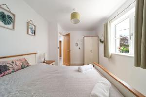 Un dormitorio con una cama grande y una ventana en Goodleigh Cottage en Goodleigh