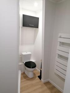 ein weißes Bad mit einem WC und einem schwarzen Sitz in der Unterkunft Studio à deux pas de la mer in Berck-sur-Mer