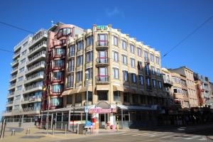 un grand bâtiment au coin d'une rue dans l'établissement Hotel La Terrasse, à La Panne