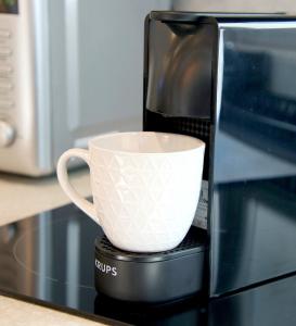 a coffee cup is sitting on top of a microwave at Falcon Apartments Center 1 in Warsaw
