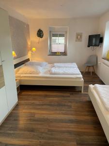 a bedroom with two beds and a wooden floor at Villa Lahr in Lahr