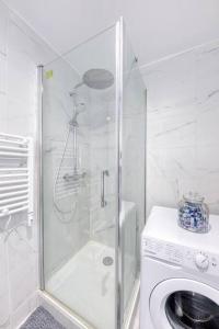 ein Bad mit einer Dusche und einer Waschmaschine in der Unterkunft Le Grand Danton - 4 personnes - Parking, Métro 7 in La Courneuve