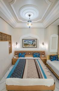 a bedroom with two beds and a ceiling at Saheb Ettabaa Tunis in Tunis