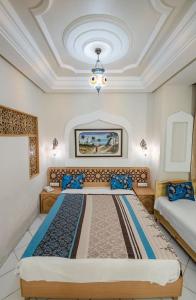 ein Schlafzimmer mit zwei Betten und einer Decke in der Unterkunft Saheb Ettabaa Tunis in Tunis + 16 Fotos