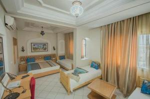 Habitación grande con 2 camas y sofá en Saheb Ettabaa Tunis, en Túnez
