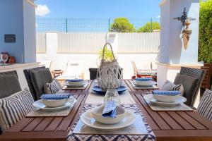una mesa de madera con platos y cuencos en un patio en Mar Menor Villa, en Torre-Pacheco