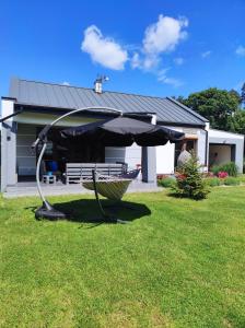 a hammock in the grass in front of a house at GOCZÓWKA in Siemiany