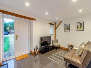 a living room with a couch and a television at Oak Cottage - Near Abergavenny in Abergavenny
