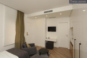 a bedroom with a bed and a couch and a desk at Moment Boutique Apartments in Belgrade