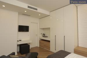 a bedroom with white walls and a bed and a desk at Moment Boutique Apartments in Belgrade